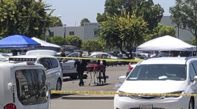 Orange County coroners remove a body of a stabbing victim from a parking lot at California State University, Fullerton on Monday, Aug. 19, 2019. An employee of the university was killed in a stabbing in a campus parking lot Monday in what police called a targeted attack, though they were not sure of a motive.