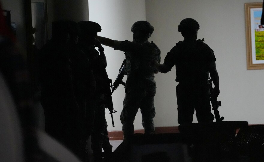 Philippine troopers exchange fire along a hallway at the Philippine Senate in Pasay, Philippines on Wednesday May 13.