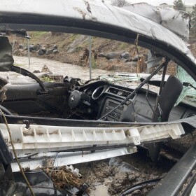 A car that had been swept away in the flooding but was now sitting in a parking lot beside Chollas Creek on Feb. 1, 2024.