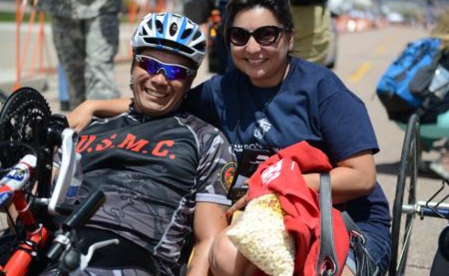 Marine Staff Sgt. Ronnie Jimenez celebrates his 10K hand-cycling win with his wife Patrice after crossing the finish line.