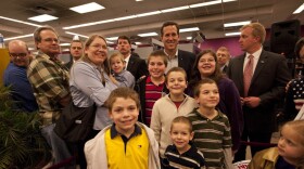 Rick Santorum poses with people at Harvest Graphics, a small business, during a campaign stop Wedneday in Lenexa, Kansas. 