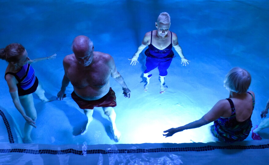 Ronnie Sherman (left), Jerry Feiner (second from left) and other seniors take part in a Hatha aqua yoga class led by yoga instructor Rebecca Watson (second from right) at Balfour at Riverfront Park in Denver in July.