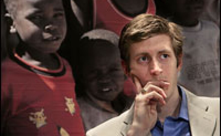 In front of a photograph of children from Darfur, Olympic gold medalist Joey Cheek participates in a 2006 news conference about the genocide in Sudan's Darfur region, in Washington, D.C.