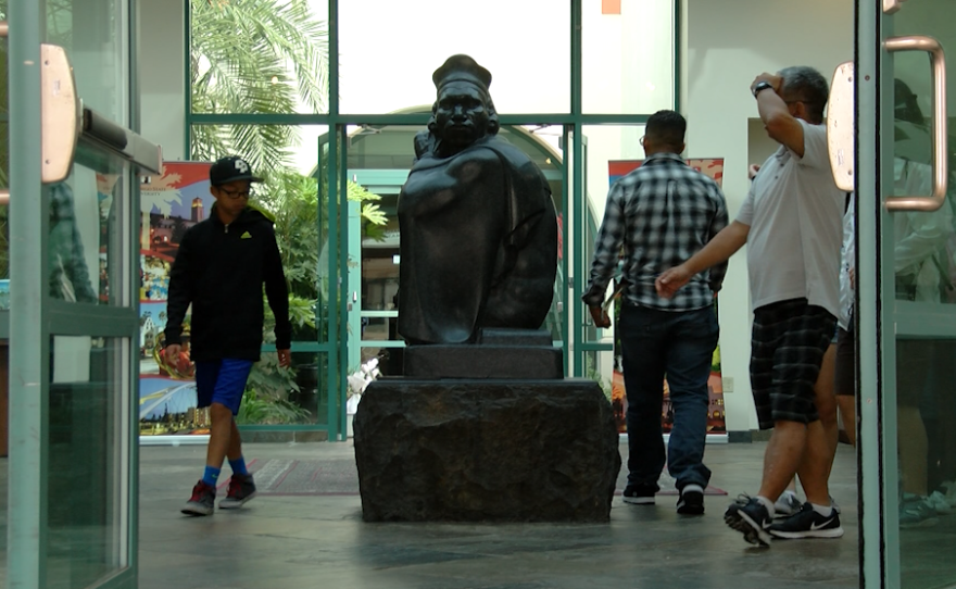 Prospective students and their families walk past a statue of Monty Montezuma gifted to the university in 1937, April 11, 2016.