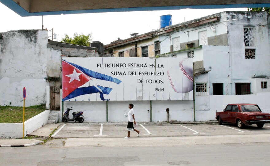 A sign in front of the stadium features a quote from Fidel Castro: "Triumph is found in the sum of all our efforts."