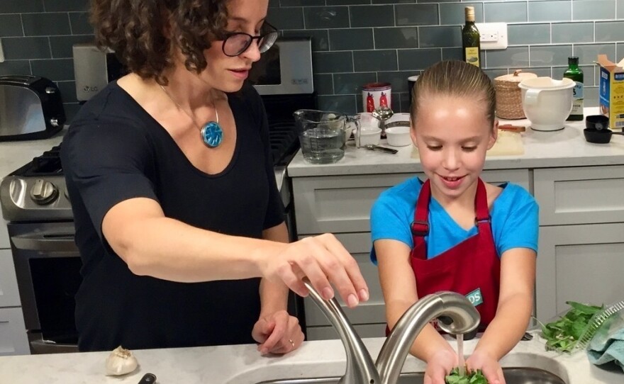 Molly Birnbaum, <em>America's Test Kitchen Kids</em> editor in chief, helps 8-year-old Lucy Gray make a one-pot pasta meal from a recipe in the new book, <em>The Complete Cookbook for Young Chefs</em>.