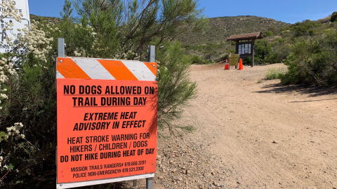 A heat advisory sign warns people to keep their pets off the trail at Cowles Mountain, June 10, 2019. 