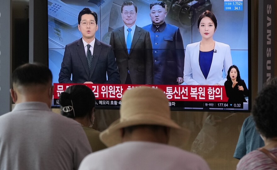A news program at the Seoul Railway Station broadcasts a report on the resumption of communication between North and South Korea on Tuesday.