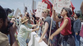 Pro Prop. 187 demonstrator Catherine Nicosia, 74, left, tries to take signs of anti Prop 187 protesters during a rally outside the Federal Building, in the Westwood section of Los Angeles on Saturday, August 10, 1996.
