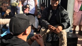 Dual resident of Otay Mesa and Tijuana Hugo Reynoso, 39, talks to Honduran migrant José Martinez at Playas de Tijuana, November 15, 2018.
