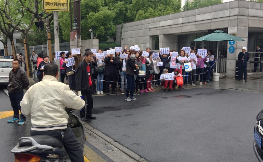 Investors in Zhongjin, a wealth-management company that collapsed this month, demonstrate outside a police office in Shanghai's Hongkou district, demanding repayment of their funds. Police later detained one of the demonstrators for distributing protest T-shirts.