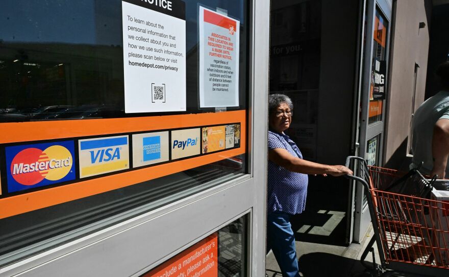 A display of credit cards accepted for use is seen on a door as a shopper steps out of a store in Monterey Park, Calif., on Sept. 12, 2023.