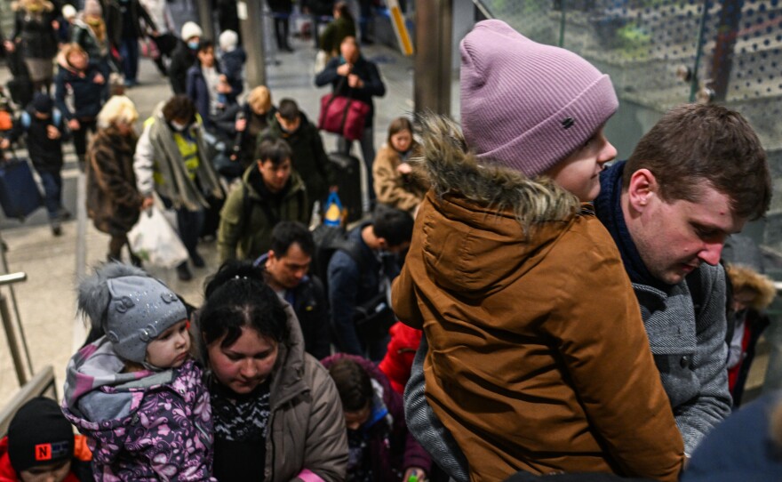 People fleeing the war in Ukraine walk towards a humanitarian train on Friday in Krakow. More than 3.4 million people have left Ukraine since Russia began its invasion almost four weeks ago.