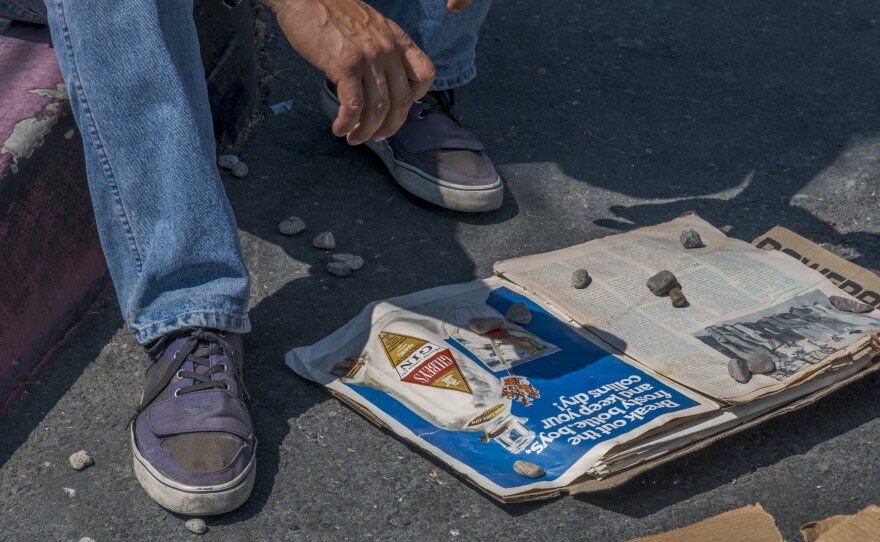 Daniel Ness' feet are pictured as he dries out pages of an old newspaper, August 15, 2023.