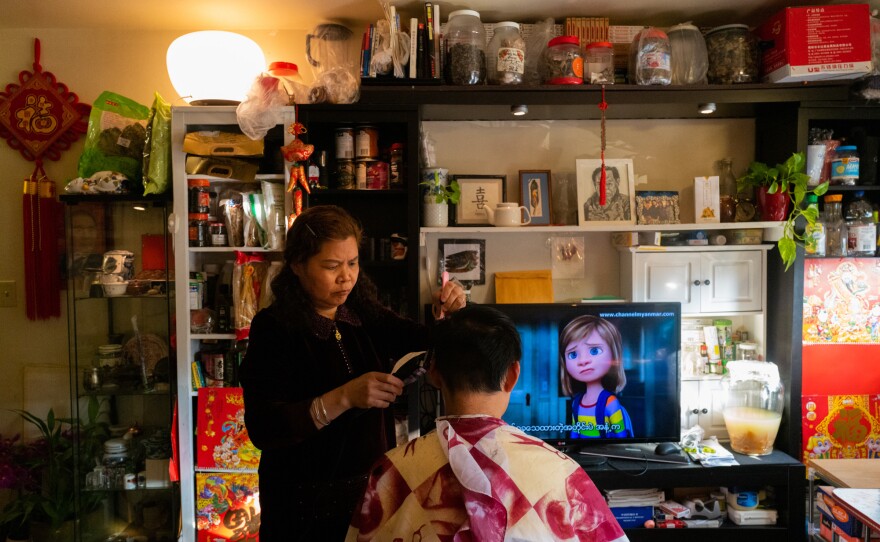 Liang gives her son Jackie a haircut.