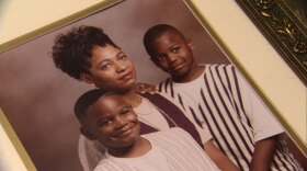 A framed photo of a mother and her two sons. 