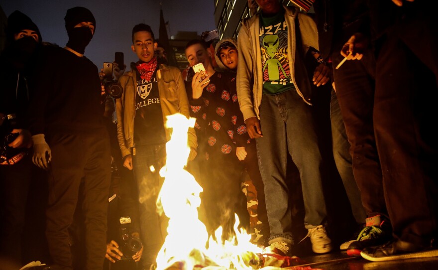 Protestors burn an American flag outside of Trump Tower in New York City on Wednesday.