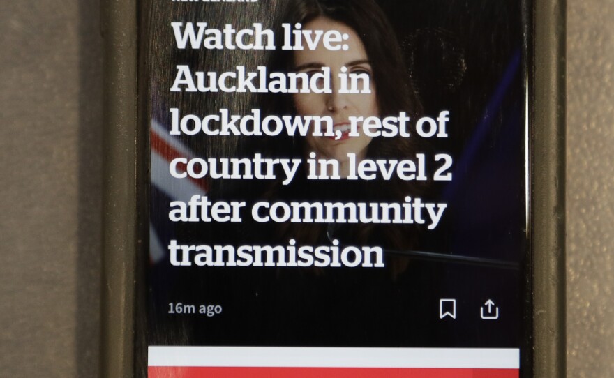 A news alert is displayed on a mobile phone in Christchurch, New Zealand, Tuesday, Aug. 11, 2020.