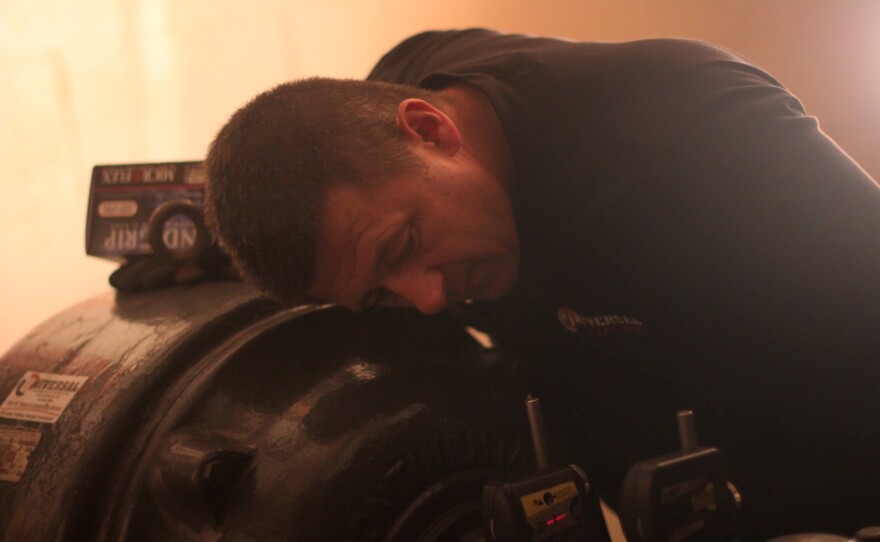 Mechanic Robert Sudo adjusts the motor of a powerful water pump that was knocked out by flooding.