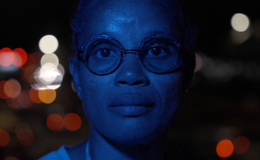 Staceyann Chin flooded in blue light in her native Jamaica.