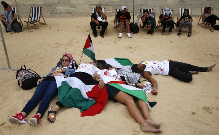 Pro-Palestinian activists stage a die-in protest at their "Gaza beach event," held near the official Tel Aviv beach event on the banks of the Seine in Paris.