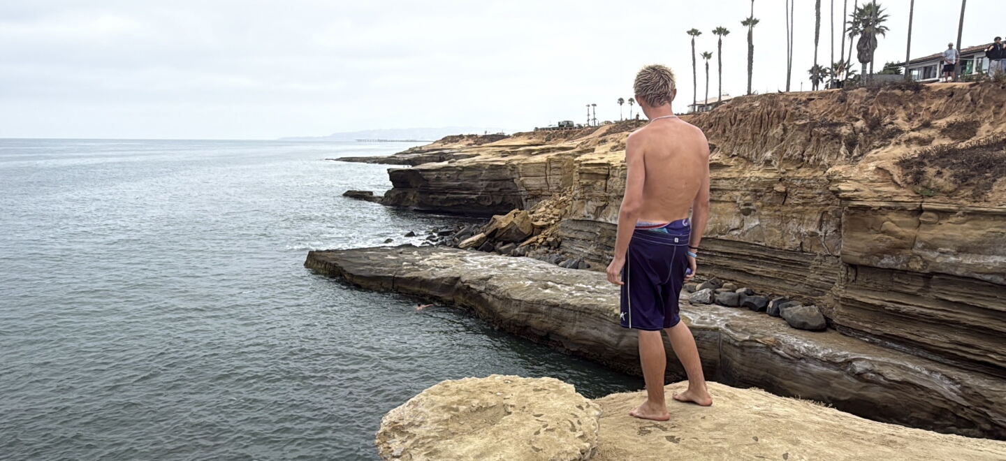 Enzo Bledsoe stands ready to cliff jump at Pappy's Point at Sunset Cliffs, Aug. 5, 2026.