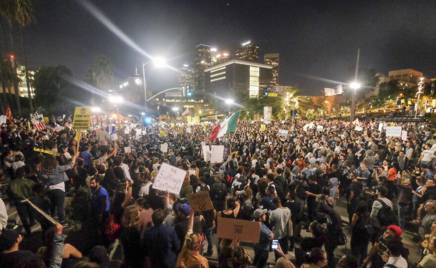 Demonstrators gather to protest a day after President-elect Donald Trump's victory, at a rally outside Los Angeles City Hall on Wednesday. Protesters burned a giant orange-haired head of Donald Trump in effigy, lit fires ins the streets and blocked traffic lanes late into the night.