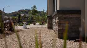 Gravel covers a five-foot non-combustible buffer in front of a model home in the Dixon Trail neighborhood of Escondido on April 24, 2025. The buffer zone helps reduce the chances of a home being ignited by the embers from a wildfire. Developer KB Home is marketing Dixon Trail as the first “wildfire resilient neighborhood” in the U.S., constructed using fire-resistant materials and methods.