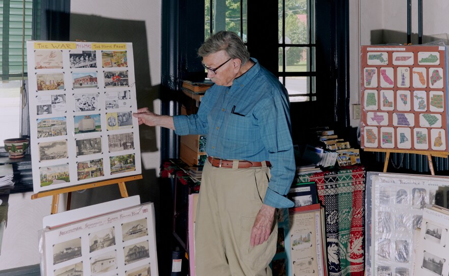 Brown stands near some of the many boards of archived postcards inside his home.