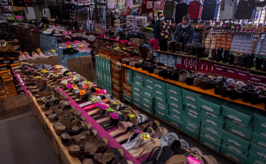 An employee at the San Ysidro shoe store Carloin Shoes helps a customer choose a blanket to buy, San Ysidro. November 8, 2021.