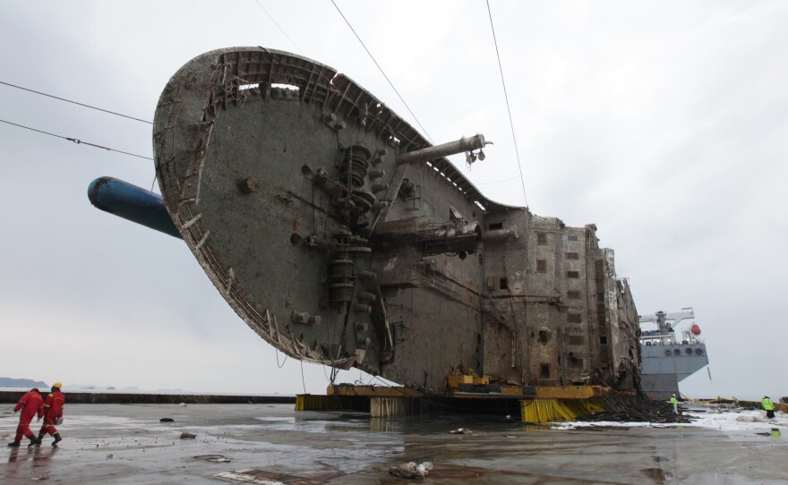 The ferry Sewol sits on a semi-submersible transport vessel during the salvage operation in waters off the island of Jindo on Sunday. On Tuesday, South Korean officials said remains believed to be from some of the missing victims were recovered by salvage workers.