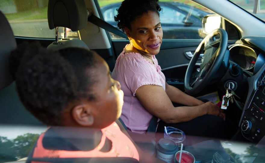 Muse-Dennis talks to her daughter Loralyn Dennis, 10, as they wait for school to open. Muse-Dennis says raising two daughters as a single mom on a teacher's salary has forced her into a 65-hour workweek.