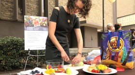 Tracey Grant with Sharp Rees-Stealy's Center for Health Management organizes fruit on a table outside of city hall, July 17, 2018.