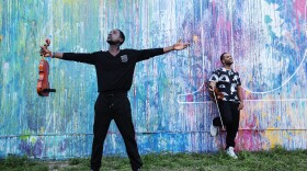 Wilner Baptiste (front) Kevin Sylvester (back) standing in front of a mural in this undated photo.