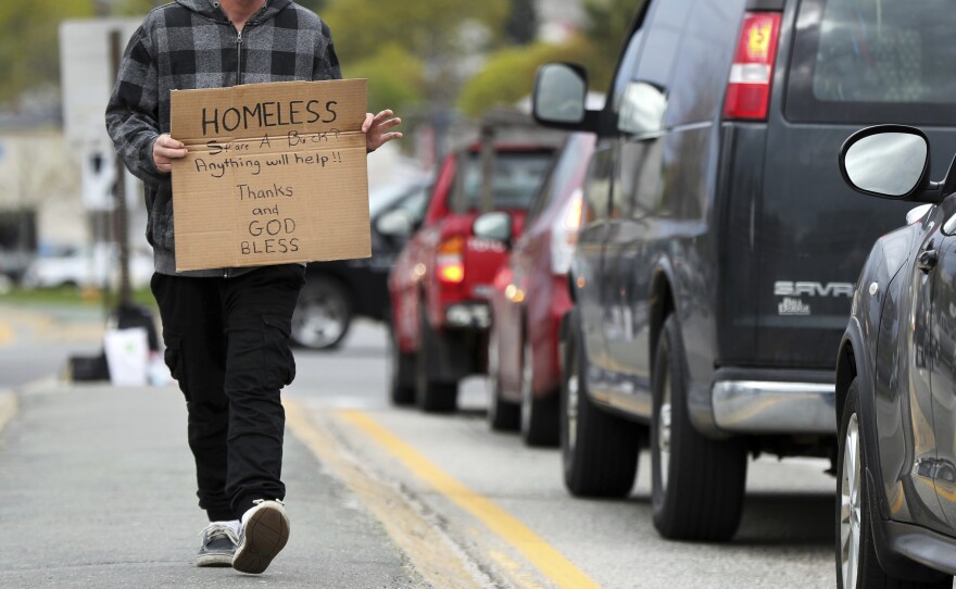 A man panhandles in the median strip on a street in Portland, Maine, in 2017. A federal judge in Arkansas ruled Tuesday that a law forbidding panhandlers to physically interact with people in cars is unconstitutional.