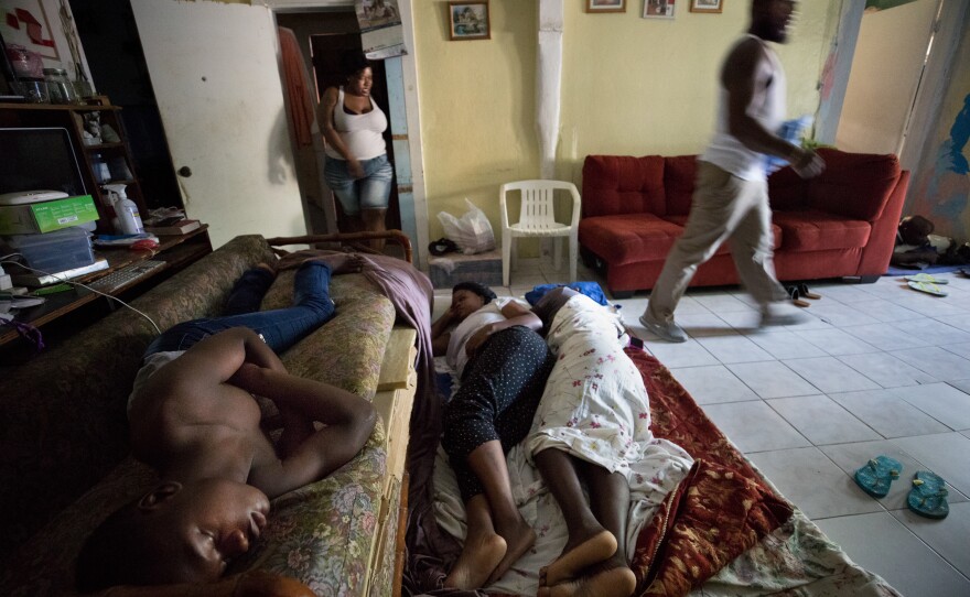 From left: Justin Bain, Sherrine Petit Homme LaFrance and Ferrier Petit Homme have little space to sleep in the family home of China and brother Odne Laguerre, who have taken in 10 Haitian evacuees from Abaco.