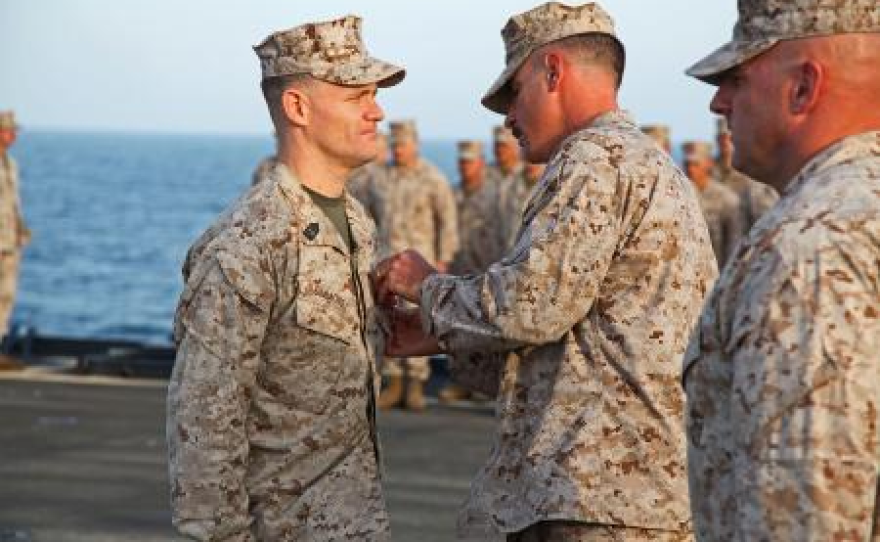 Lieutenant Col. John Wiener, commanding officer, Combat Logistics Battalion 15, 15th Marine Expeditionary Unit, pins the Bronze Star with Combat Distinguishing Device on 1st Sgt. Bradley G. Simmons, Sergeant Major, CLB-15, 15th MEU, during his award ceremony aboard the USS Rushmore, Jan. 25.