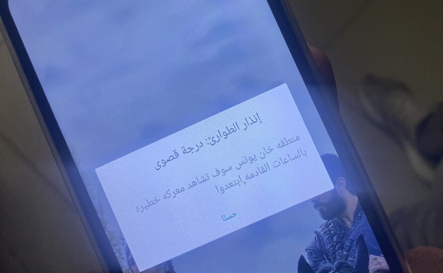 A resident in Rafah shows a text alert on their phone from the Israeli military warning them of a dangerous battle in Khan Younis and to "stay away."