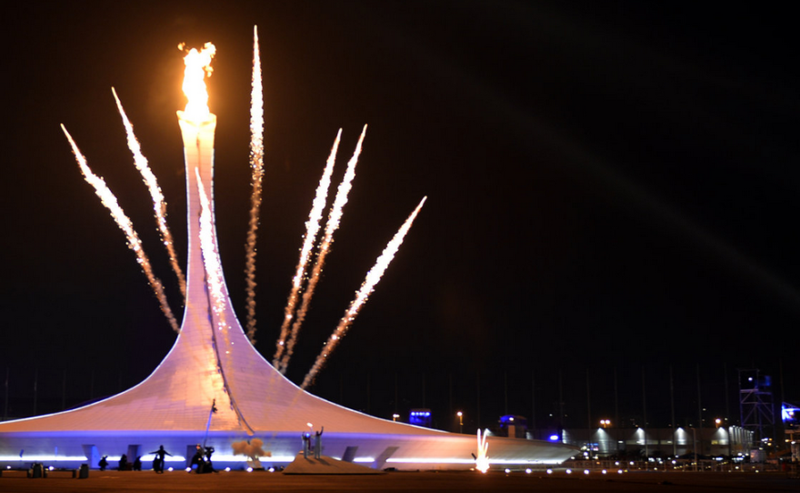 Fireworks explode behind the Olympic flame cauldron, announcing the official opening of the Sochi Winter Olympics.