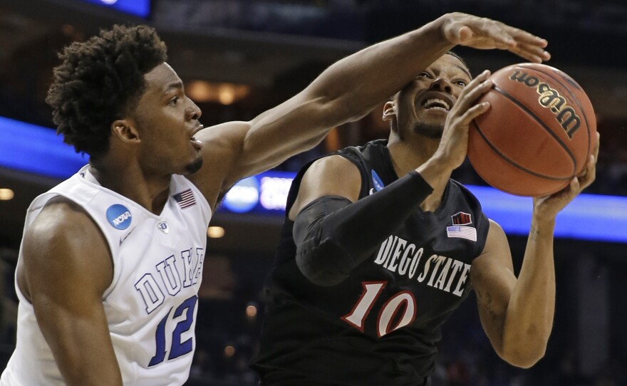 Duke's Justise Winslow (12) blocks a shot by San Diego State's Aqeel Quinn (10) during the second half of an NCAA tournament college basketball game in the Round of 32 in Charlotte, N.C., March 22, 2015. Duke won 68-49. 