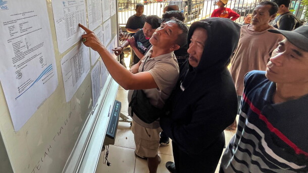 People check the passenger manifest of Virgo Transport 8 passenger ferry which overturned in bad weather in the Java Sea, at the rescuers' command center in Banjarmasin, South Kalimantan, Indonesia, Monday, Sept. 14, 2026.