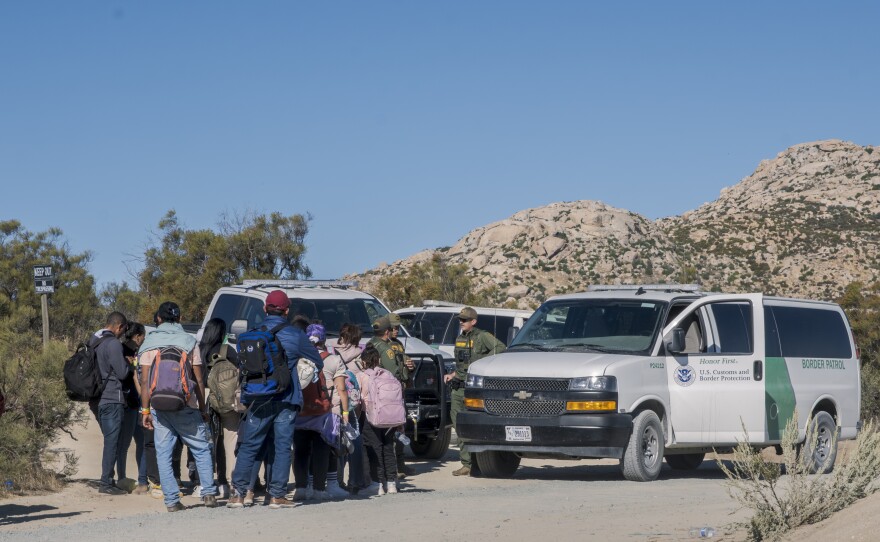 U.S. Customs and Border Protection load migrants into vans to take them to processing centers after the migrants waited for hours to days in the desert near Jacumba Hot Springs, Oct. 6, 2023.