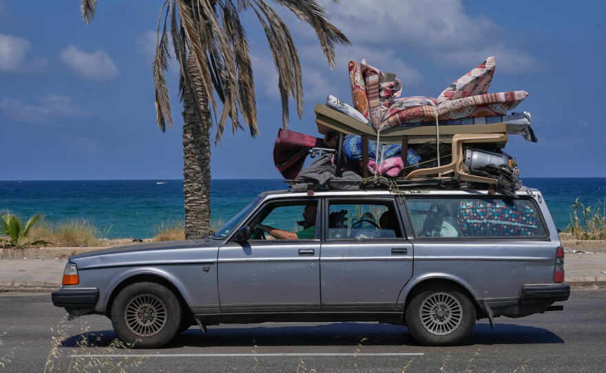 A displaced family with their belongings return to their village following a ceasefire between Israel and Hezbollah in the southern port city of Sidon, Lebanon, Tuesday.