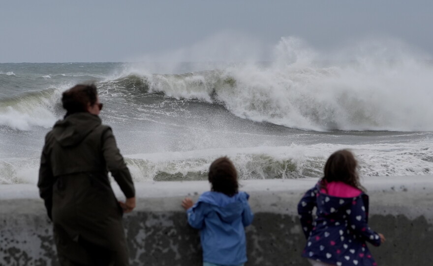 Spectators watch wave break during a nor'easter storm on Saturday in Hampton, N.H.