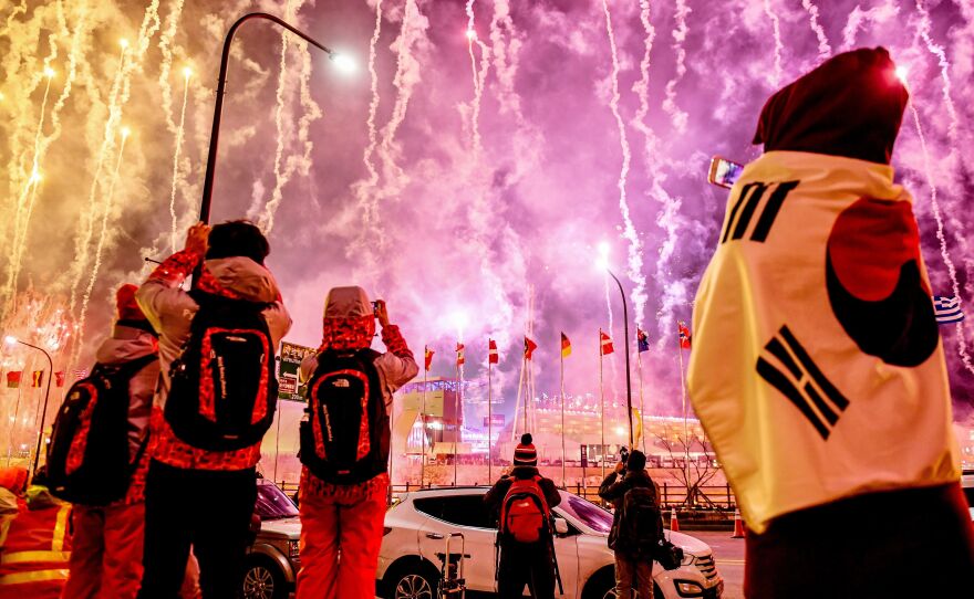 Spectators watch fireworks go off at the start of the opening ceremony.