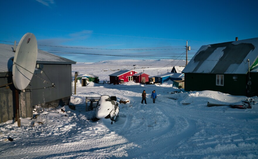 People walk through Toksook Bay, an Alaskan fishing village along the Bering Sea.