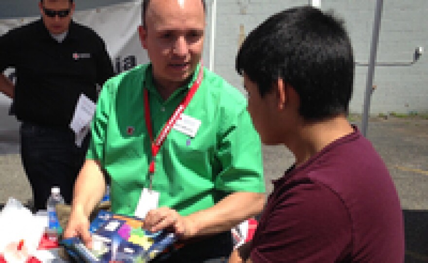 Mario Medrano of the American Red Cross speaks to an attendee about tornado safety at the Children's Day Festival in Oklahoma City.