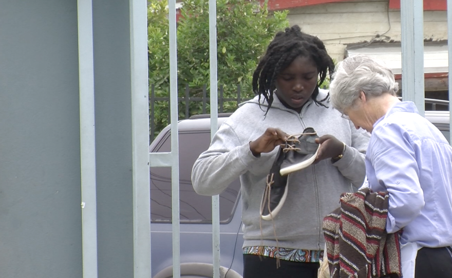 A Haitian migrant inspects donated shoes at the Tijuana shelter Madre Asunta, June 9, 2016.