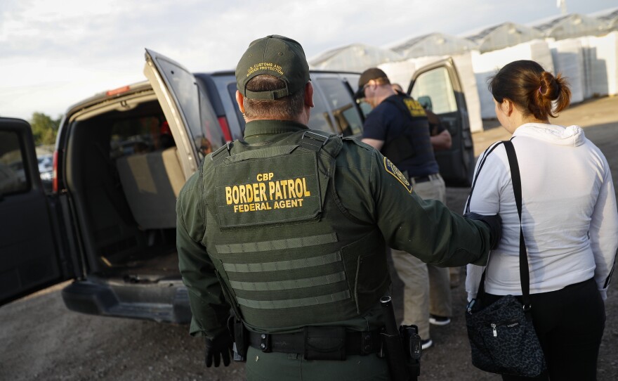 Government agents apprehend suspects during an immigration sting at Corso's Flower and Garden Center Tuesday in Castalia, Ohio. It's one of the largest against employers in recent years on allegations of violating immigration laws.