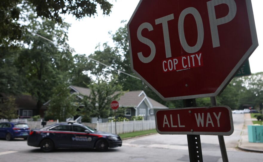 A police car drives through an intersection near Brownwood Park where a stop sign has been modified in opposition to the Atlanta Public Safety Training Center that protesters refer to as "Cop City," in Atlanta, Georgia, U.S., June 24, 2023.